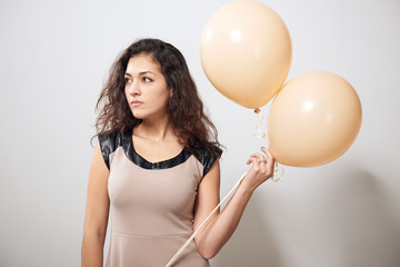 young woman or teen girl in brown dress with helium air balloons