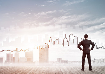 Motivation and inspiration concept with modern cityscape and businessman observing it