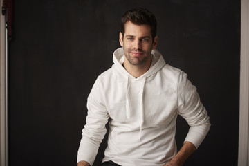 Young man studio portrait. Close-up shot of a young businessman standing at dark background and looking at camera. 