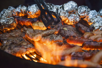 Płonący grill pełny jedzenia i mięsa - 186583358