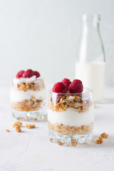 Healthy breakfast with oats granola,raspberry and nuts over wooden table