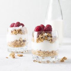 Healthy breakfast with oats granola,raspberry and nuts over wooden table