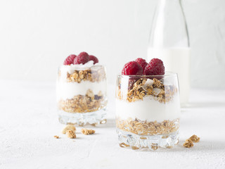 Healthy breakfast with oats granola,raspberry and nuts over wooden table