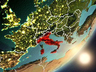 Sun rising above Italy from space