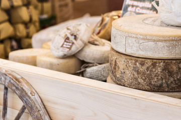 Сheese wheels of aged cheese on a farmer's market