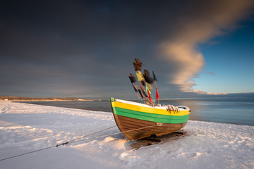 Fishing boat at snow covered beach in Sopot. Winter landscape. Poland.
