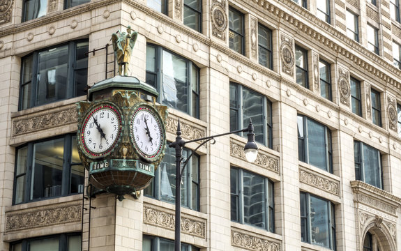 A Clock hanging on the angle of a  building fine decorated at the financial district, Chicago, IL, USA on the 3rd of August, 2017