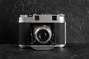 The vintage medium format film camera on black cement background.