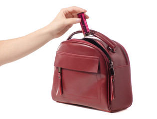 Female hand put lipstick in female handbag