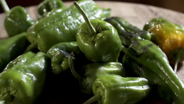 Closeup of sweating padron peppers slowly turning for the camera.