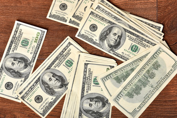 Dollars are scattered on the table. 