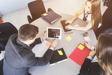 Business meeting of a man and two women at a round table