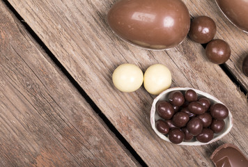 Easter eggs and sweets on aged wooden background