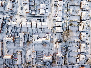 Fototapeta premium Aerial view of snow covered traditional housing suburbs in England. Snow, ice and adverse weather conditions bring things to a stand still in the housing estates of a British suburb