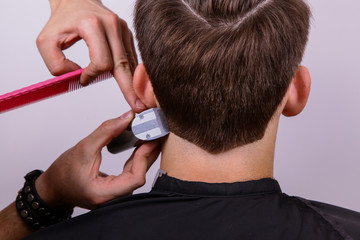 The process of male haircuts. A hairdresser is cutting a guy. Barber does a haircut.Hair will be sheared, hair cut. The machine for a hairstyle