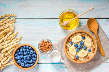 Breakfast with oat flakes, natural milk, fresh banana, almonds and honey.