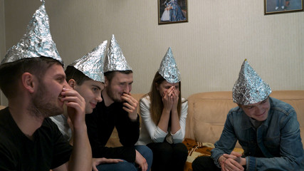 Friends with foil on their heads having fun at party. You know, so they can't read your mind