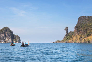 Fototapeta na wymiar Longtail boats sailing in tropical andaman sea at Koh Kai or chicken rock island, Krabi, Thailand is popular for tourist snorkelling trip