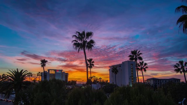 Tropical time lapse at sunset with hotels, palm trees and clouds