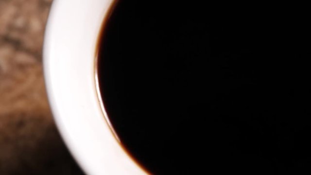 Slider shot of coffe in cup from above the cup.