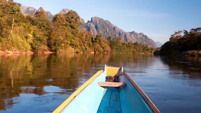 rapid river boat trip with rocky mountains in background slow motion. Vang Vieng, Laos
