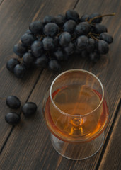 A snifter of cognac or brandy with a bunch of grapes