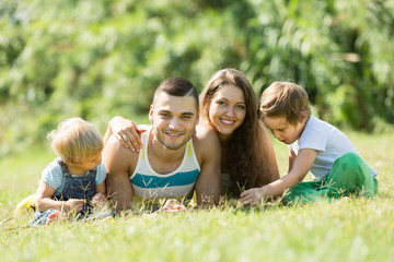 Fototapeta premium Rodzice z dziećmi na trawie