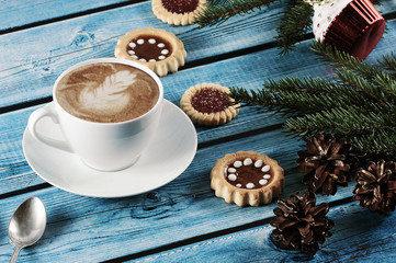Cappuccino on the new year background - fir tree, cones, cookies