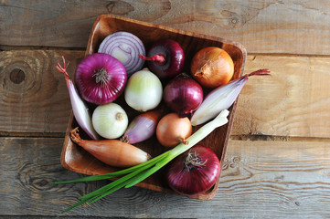 different onion varieties in a wooden plate