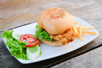 Fried fish hamburger on wooden table 