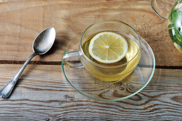 glass mug of tea with ginger and slice of lemon