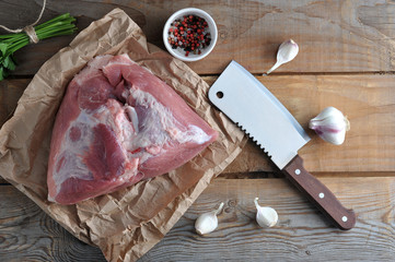 raw piece of pork big ham and a big chopping knife - Powered by Adobe