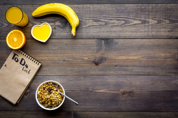 Good morning habits. Eat porridge and fruits and make to do list. Dark wooden background top view copyspace