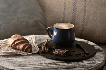 Morning Breakfast at cafe cappuccino in a mug with milk foam and a croissant