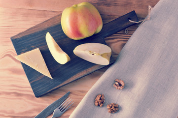Parmesan cheese and an Apple on the Board and peeled walnuts