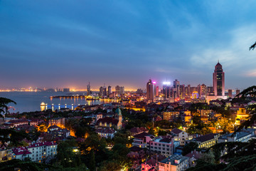 Obraz premium Qingdao Bay and the Lutheran church seen from the hill of Signal Park at evening, Qingdao, China