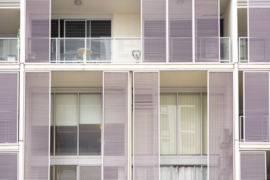 Modern Residential Building Exterior Closeup With Balcony And Shutters