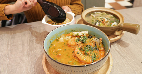 Woman eating hot soup in restaurant