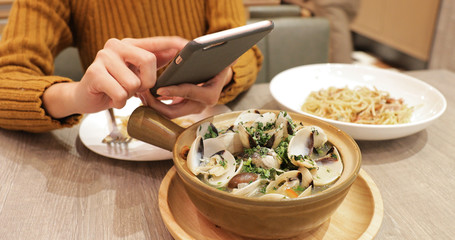 Woman taking photo on bowl in restaurant