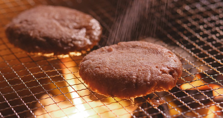 Grilling burger on BBQ fire