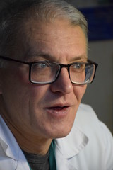 мечтающий кавказский мужчина в медицинском халате  