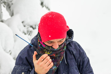 Freerider man talking on a portable radio set in a snowy forest