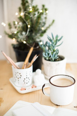 Mug of hot winter drink on table with home office details 