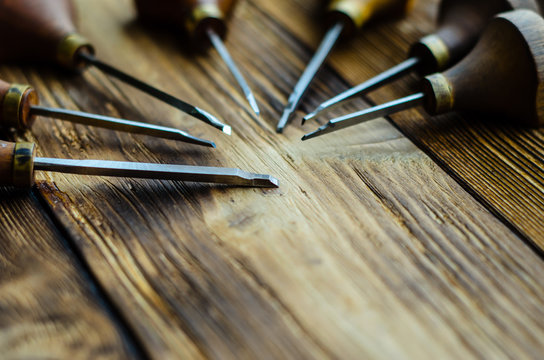 Different gravers for jewelry on wooden background