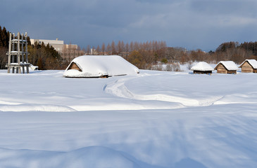 Fototapeta na wymiar 雪に覆われる厳寒期の三内丸山遺跡竪穴住居・掘立柱建物復元