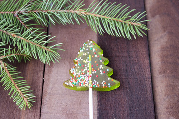 candy in the shape of a Christmas tree and Christmas tree on wooden background