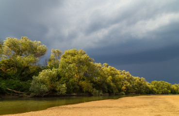 Storm clouds over wild river in summer