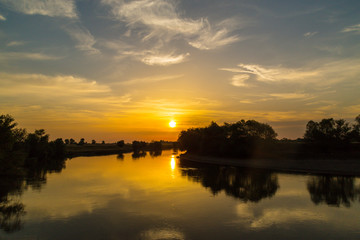 Colorful sunset over wild river in remote rural area, in autumn