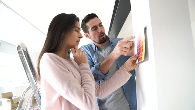 Couple looking at colour sample to renovate home interior
