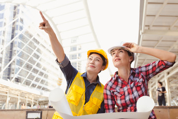 Engineers two woman working on plan building construction with laptop in city